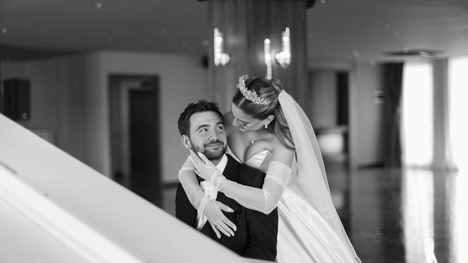 Bride and groom smiling side by side in an elegant wedding portrait